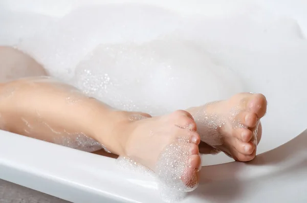 Hermosa mujer en espuma de baño belleza salud piernas — Foto de Stock