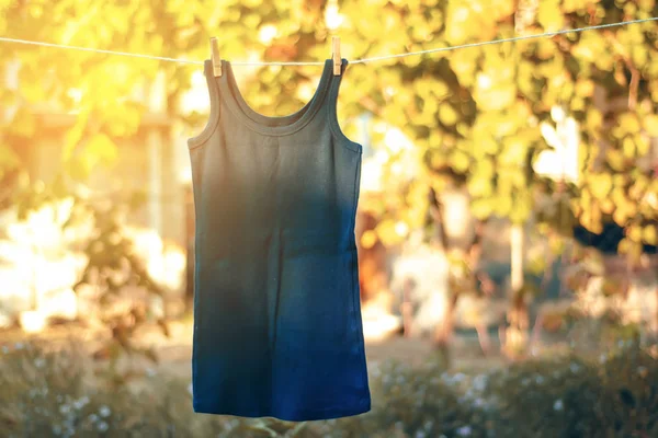 Camisa azul pendurada em uma natureza de espinha de roupa — Fotografia de Stock