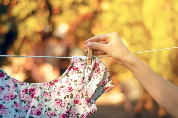 Bloem print T-shirt opknoping op een wasknijper vrouwelijke hand natuur — Stockfoto