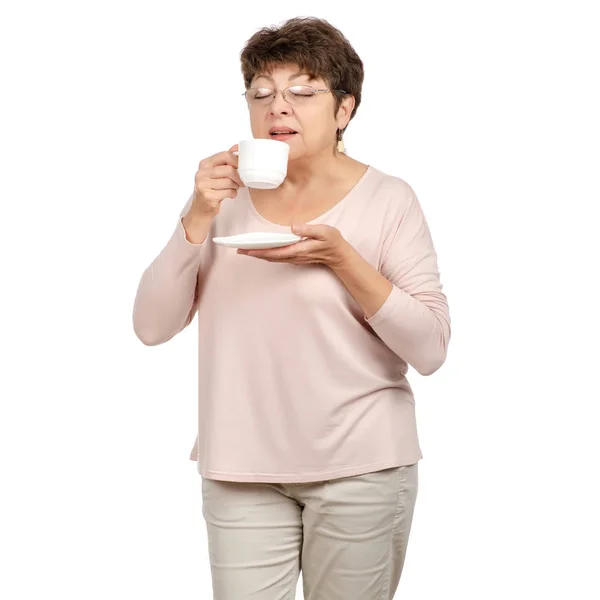 Beautiful woman aged with glasses in hand a cup and saucer tea coffee — Stock Photo, Image