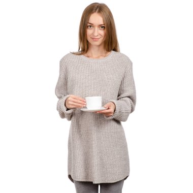 Bir beyaz Kupası ve fincan tabağı, elinde tutan kazaklı genç kadın sıcak kahve içme.