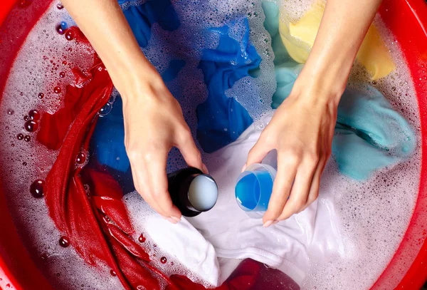 Women washing color clothes in basin enemale powdered detergent liquid laundry gel — Stock Photo, Image