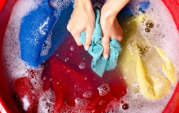 Mulheres lavando roupas coloridas na bacia enemale detergente em pó — Fotografia de Stock