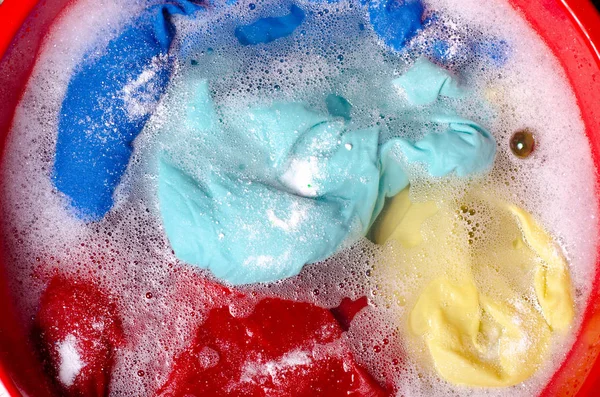 Прання кольорового одягу в басейні жіночого порошкоподібного миючого засобу — стокове фото
