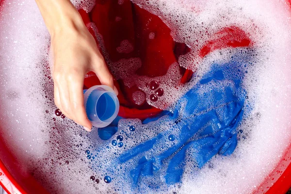 Женщины стирают цветную одежду в бассейне эмали порошок моющего средства жидкий гель для стирки — стоковое фото