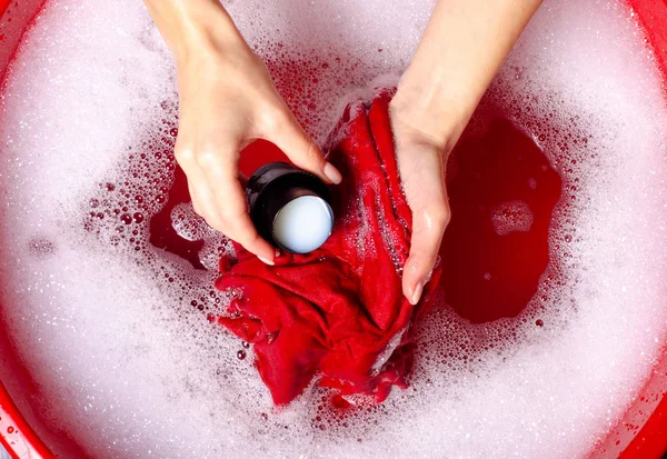 Women washing color clothes in basin enemale powdered detergent liquid laundry gel — Stock Photo, Image