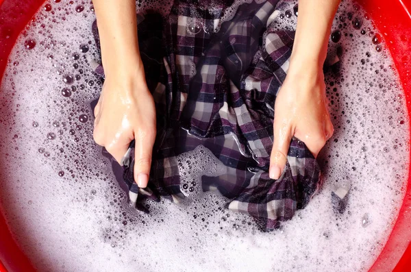 Mujeres lavado de ropa de color camisa en la cuenca enemale detergente en polvo — Foto de Stock