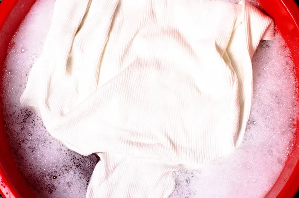 Прання білого светрного одягу в басейні жіночого порошкоподібного миючого засобу — стокове фото