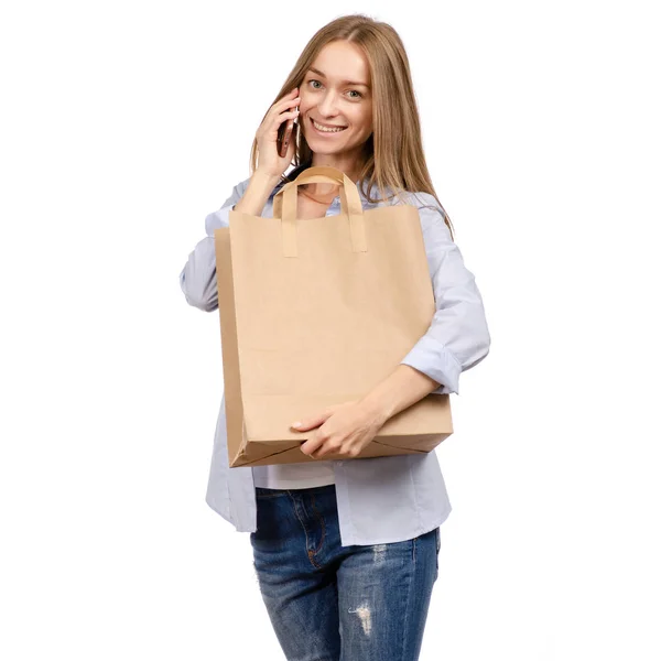 拿着纸袋的妇女智能手机手机购物美女 — 图库照片