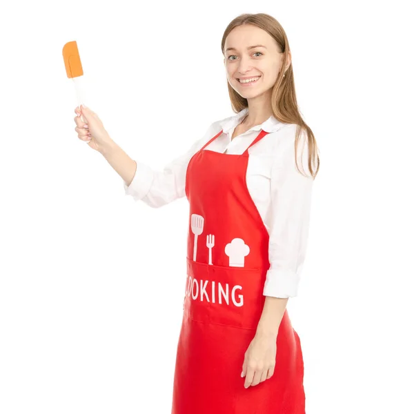 Una mujer en un delantal rojo en las manos de una espátula de cocina — Foto de Stock