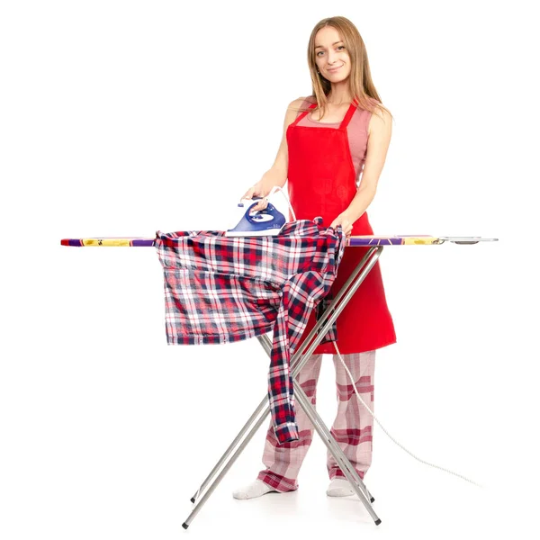 Wanita cantik dengan celemek menyetrika kemeja di papan setrika dengan besi — Stok Foto