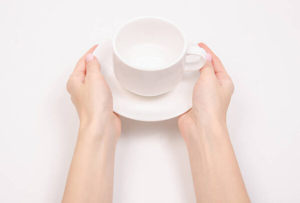Чашка белого блюдца в руке
