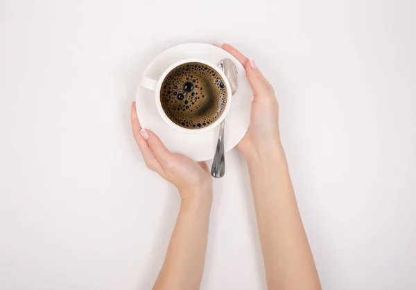 Šálek kávy espresso americano lžící v ruce na bílém pozadí — Stock fotografie