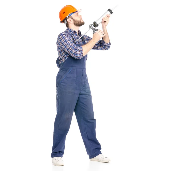 Young man builder industry worker hardhat with a silicone gun — Stock Photo, Image
