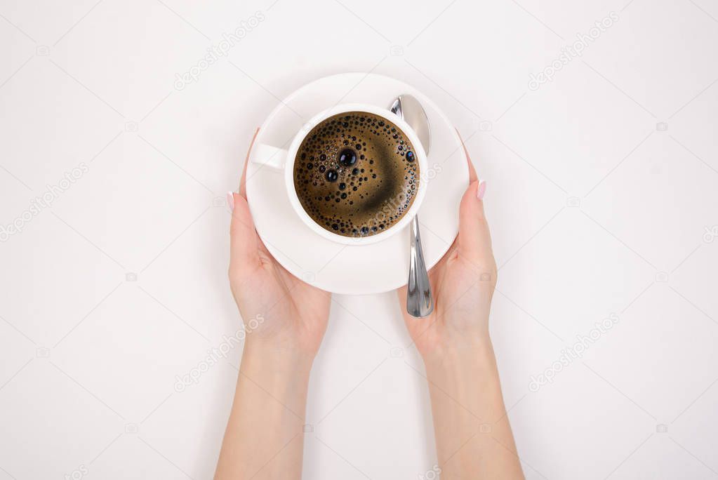 The cup of coffee espresso americano spoon in hand on white background