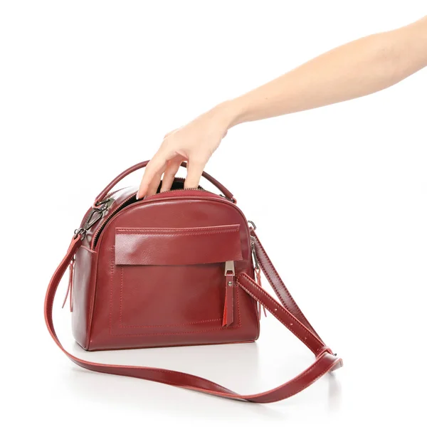 Женская красная кожаная сумка в руке достает из сумки — стоковое фото