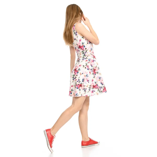 Hermosa mujer en vestido con flores print y zapatillas de deporte mostrando emociones positivas con teléfono móvil smartphone — Foto de Stock