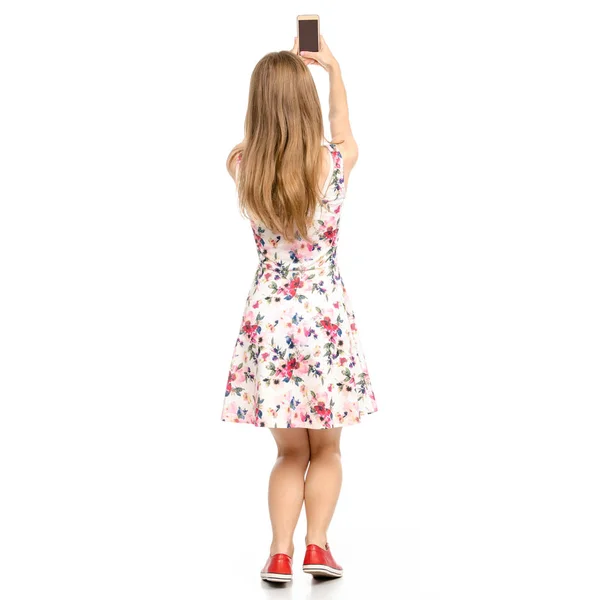 Mooie vrouw in jurk met bloemen print en sneakers vertoning van positieve emoties met smartphone GSM selfie — Stockfoto