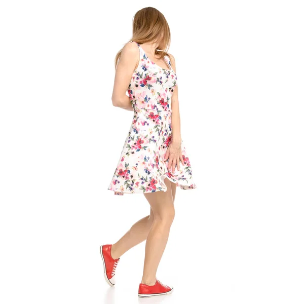 Schöne Frau in Kleid mit Blumen-Print und Turnschuhen zeigt positive Emotionen geht glücklich — Stockfoto