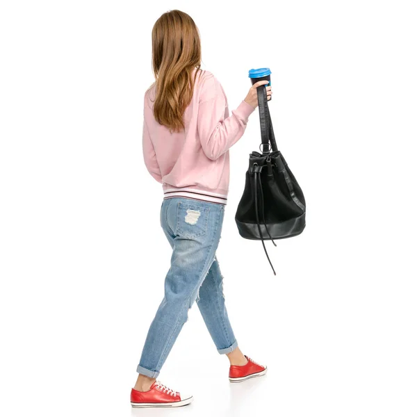 Mooie vrouw in jeans met een rugzak wandelen gaat kopje koffie in de hand — Stockfoto