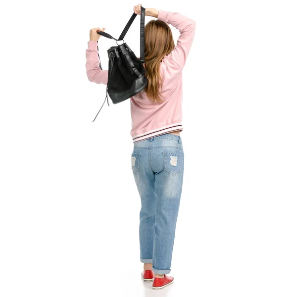 Schöne Frau in Jeans mit einem Rucksack zu Fuß geht — Stockfoto
