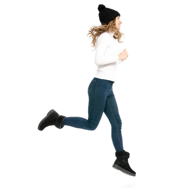 Hermosa mujer en jersey jeans sombrero frío mostrando de emociones positivas corre saltando — Foto de Stock