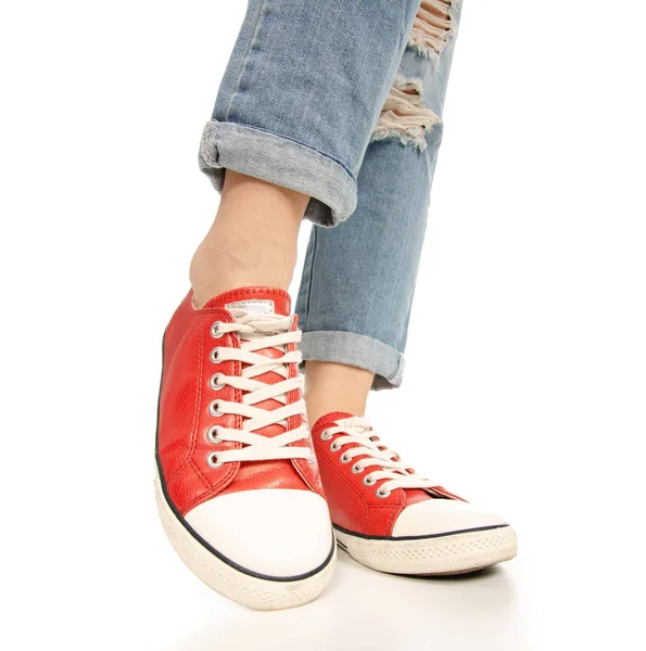 Woman legs feet jeans red sneakers hipster style — Stock Photo, Image