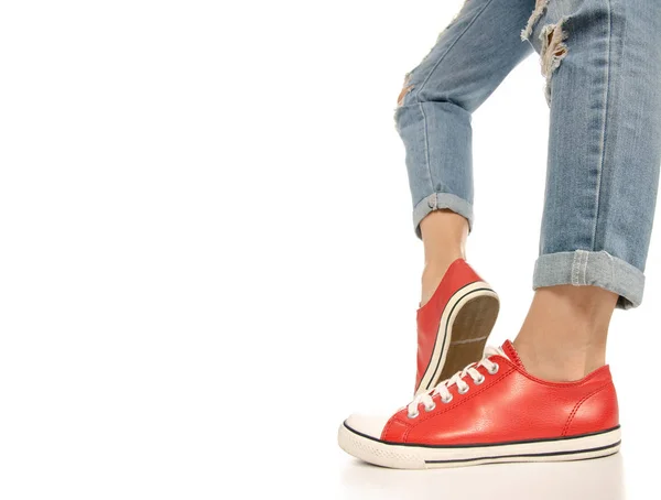 Kobieta nogi stopy jeans czerwone trampki hipster stylu, widok z boku — Zdjęcie stockowe