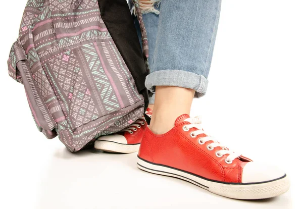 Kobieta nogi stopy jeans czerwone trampki hipster stylu z plecaka — Zdjęcie stockowe