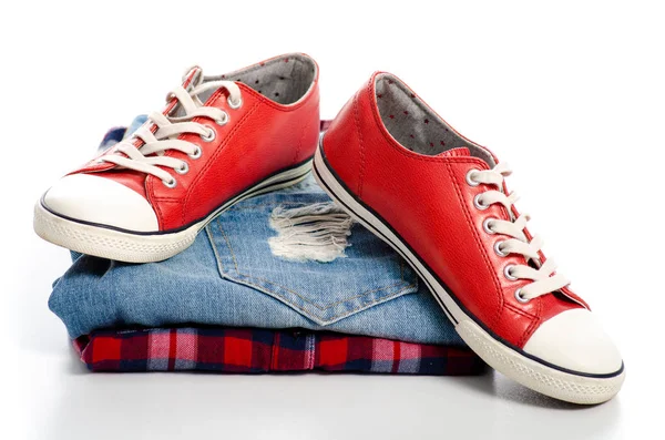 Stack av kläder och röda sneakers — Stockfoto