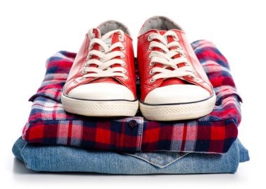 Giyim ve kırmızı spor ayakkabılar yığını