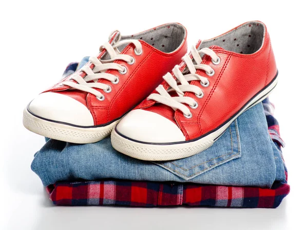 Stos ubrań i czerwone trampki — Zdjęcie stockowe