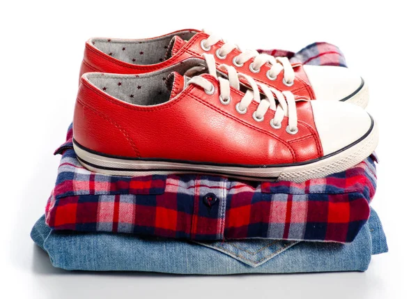 Stos ubrań i czerwone trampki — Zdjęcie stockowe