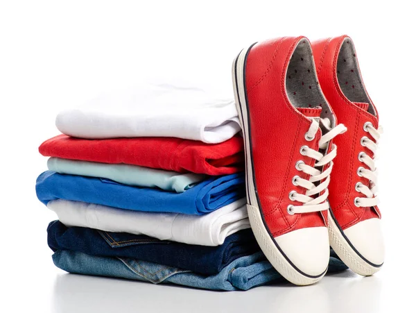 Stack of clothes and red sneakers