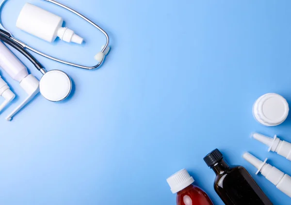 Tıbbi kavramı. Mavi arka plan üzerinde stetoskop, ilaç, sray burun boğaz üstten görünüm — Stok fotoğraf