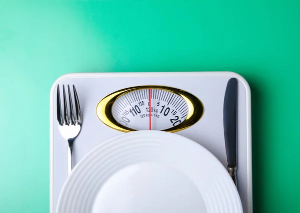 Met een gewicht van schaal plaat vork mes centimeter op groene achtergrond — Stockfoto