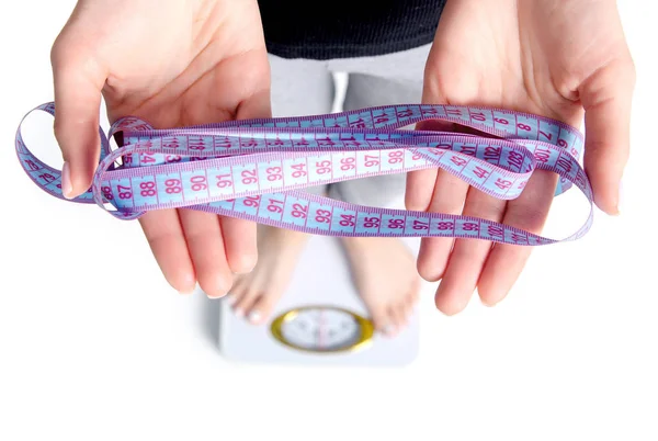 A woman stands on scales in the hands centimeter — Stock Photo, Image