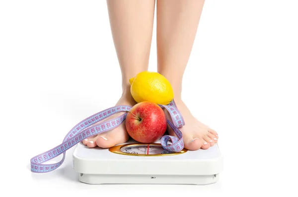 Kvinnliga fötter väger skala centimeter äpple citron — Stockfoto