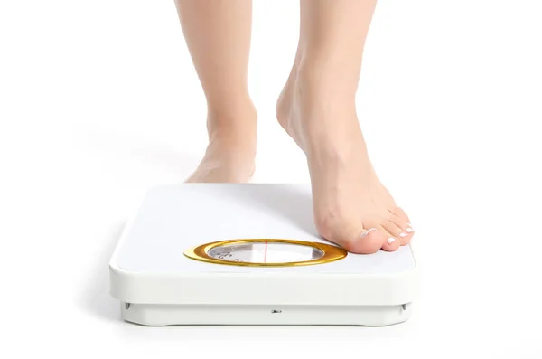 Ölçek üzerinde beyaz arka plan yalıtım ağırlığındaki kadın ayakları