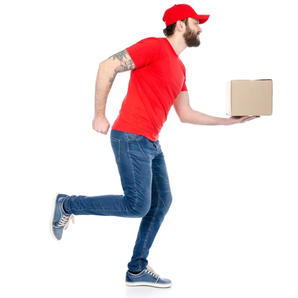 Entrega homem em vermelho uniforme segurando caixa pacote executado — Fotografia de Stock