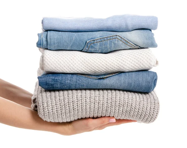 Stack of clothing jeans sweaters in hand — Stock Photo, Image