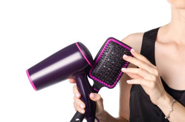 Bir saç kurutma makinesi ve tarak tutan kadın