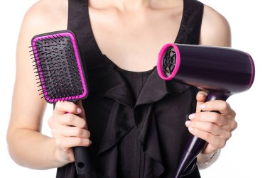 Bir saç kurutma makinesi ve tarak tutan kadın