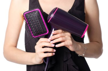 Bir saç kurutma makinesi ve tarak tutan kadın