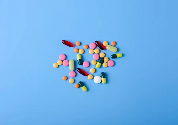 Pills capsules medicine health on blue background top view — Stock Photo, Image