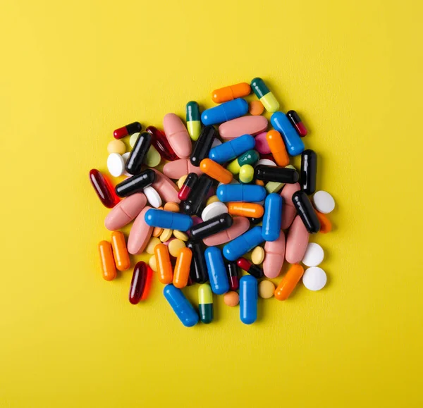 Hap kapsül ilaç sağlık üzerinde sarı arka plan üstten görünüm — Stok fotoğraf