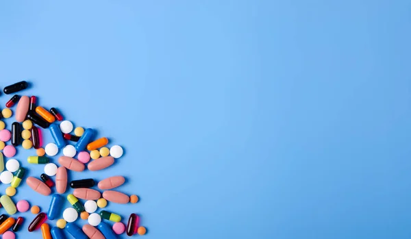 Hap kapsül ilaç sağlık üzerinde mavi arka plan üstten görünüm — Stok fotoğraf