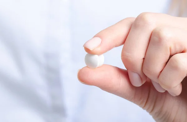 Pílulas brancas medicina na mão da mulher — Fotografia de Stock