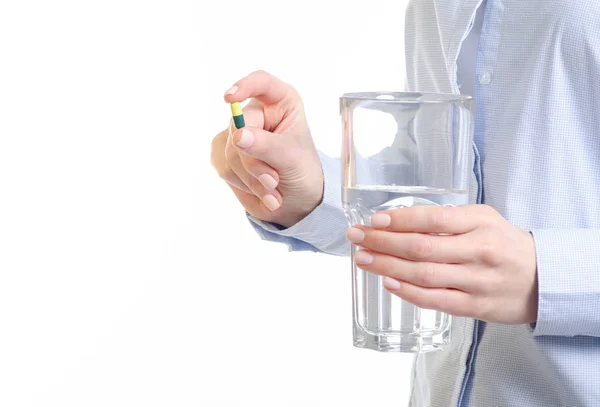 Comprimido cápsula verde e vidro de medicina da água na mão da mulher — Fotografia de Stock
