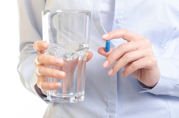 Pilule capsule bleue et verre de médecine de l'eau dans la main de la femme — Photo